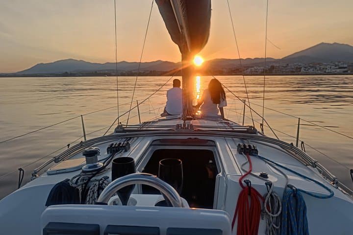 Pareja navegando al atardecer en velero privado Marbella